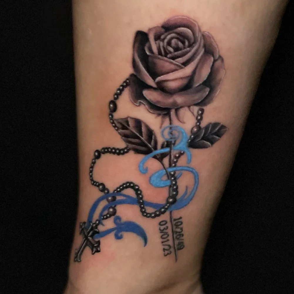 Rose tattoo with a rosary and a birthdate and death date.