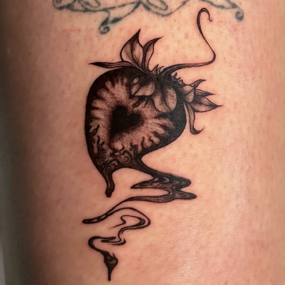 Abstract tattoo of a heart portrayed as a strawberry.
