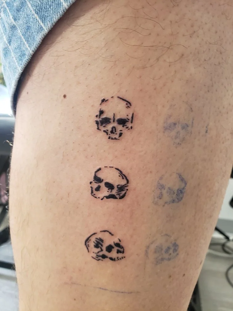 Abstract set of three skull tattoos.