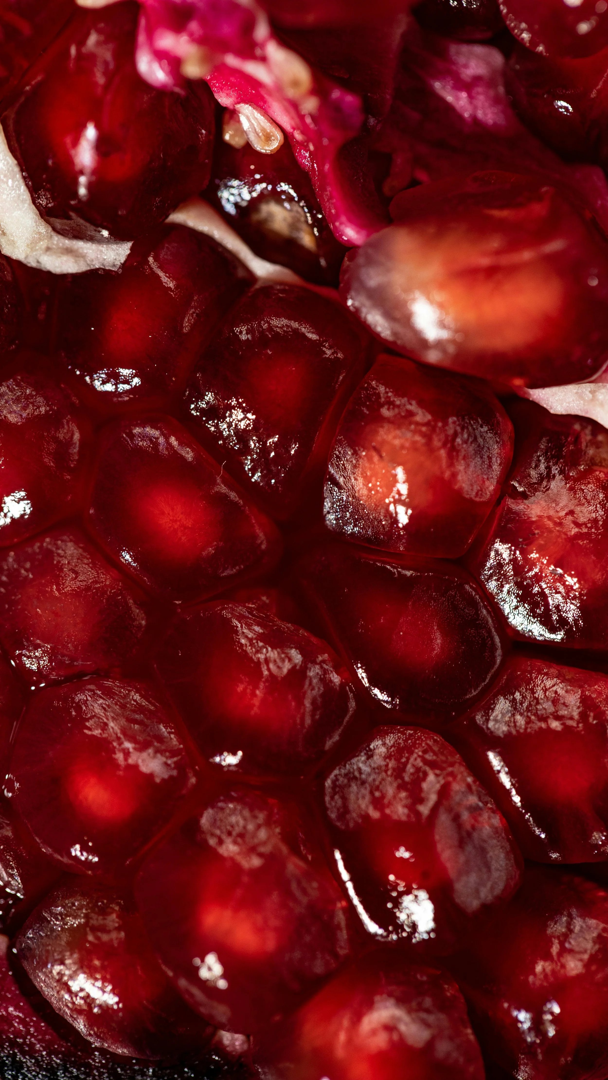 Close-up of fresh pomegranate seeds with a shiny, translucent appearance.