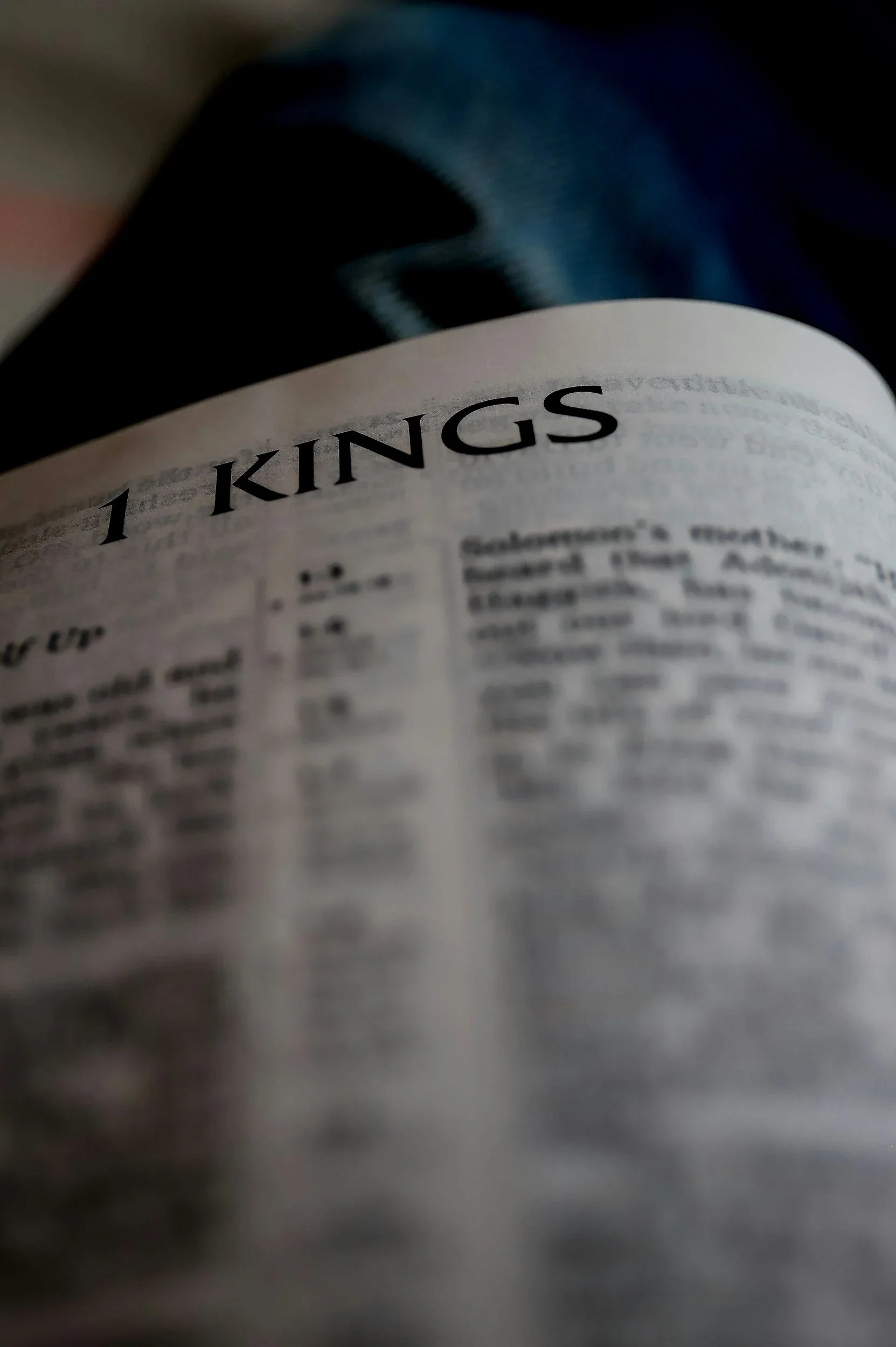 Close-up of a Bible opened to the page for 1 Kings, with the heading '1 Kings' clearly visible.