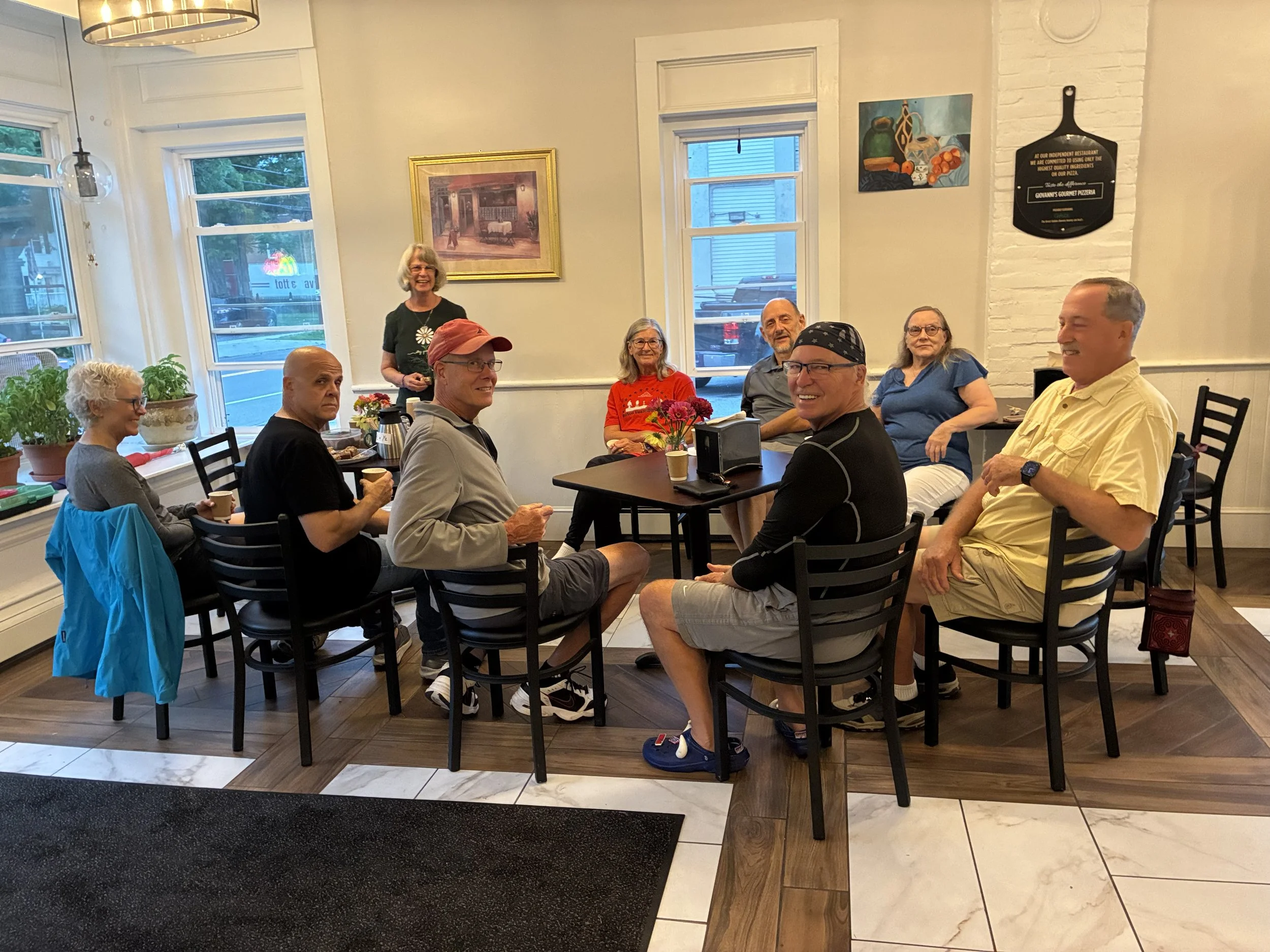 Friends and neighbors gathered around tables for coffee at Giovanni's Gourmet Pizzeria in Interlaken