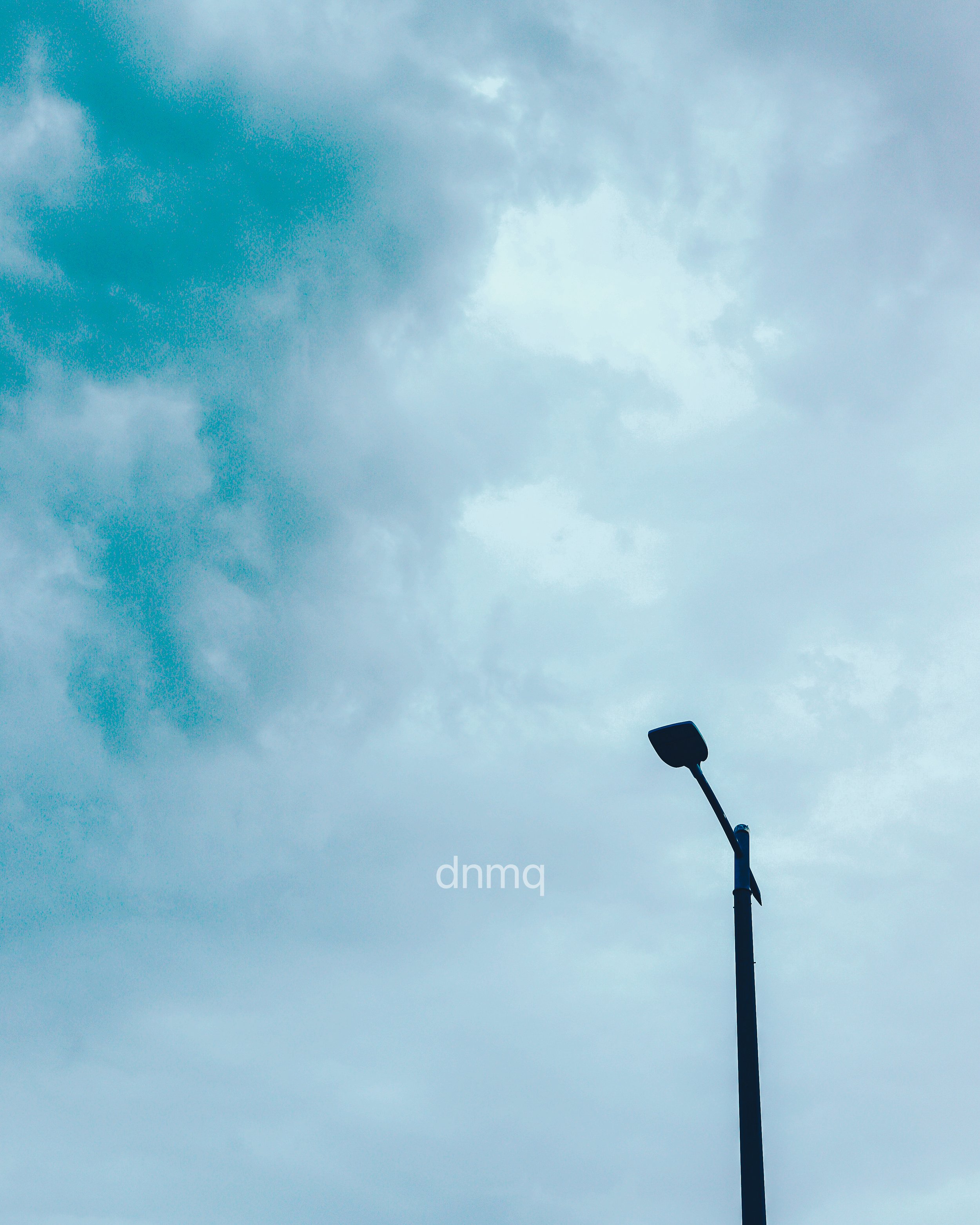 A street lamp against a cloudy sky.