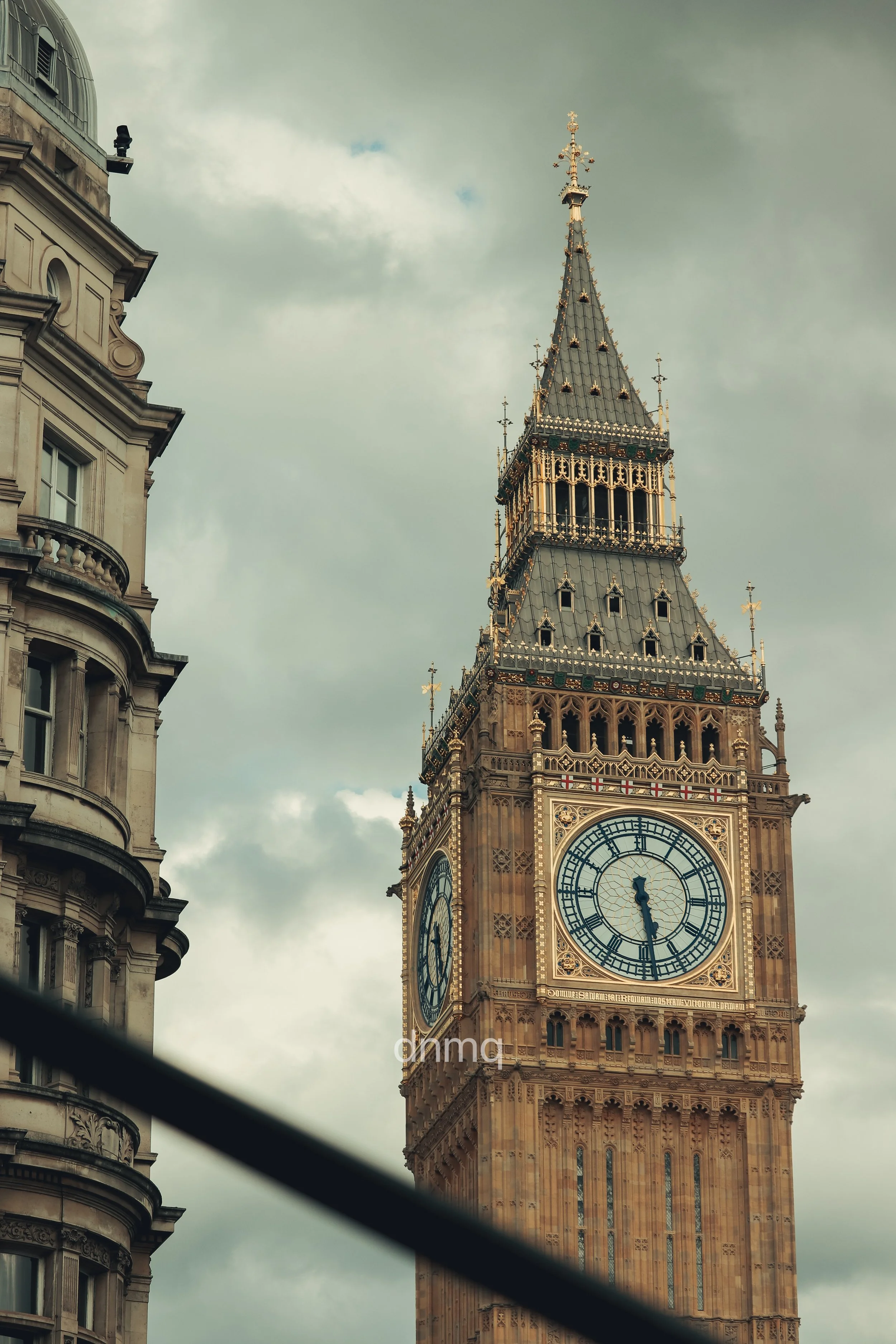 Close-up of the Big Ben clock tower with a cloudy sky in the background.