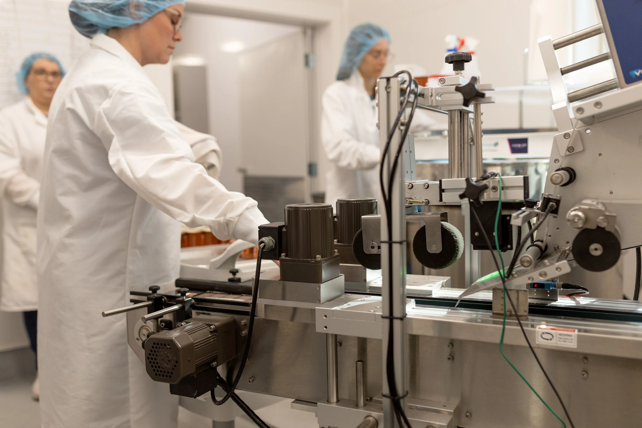 Scientists in a laboratory working with a piece of scientific equipment.