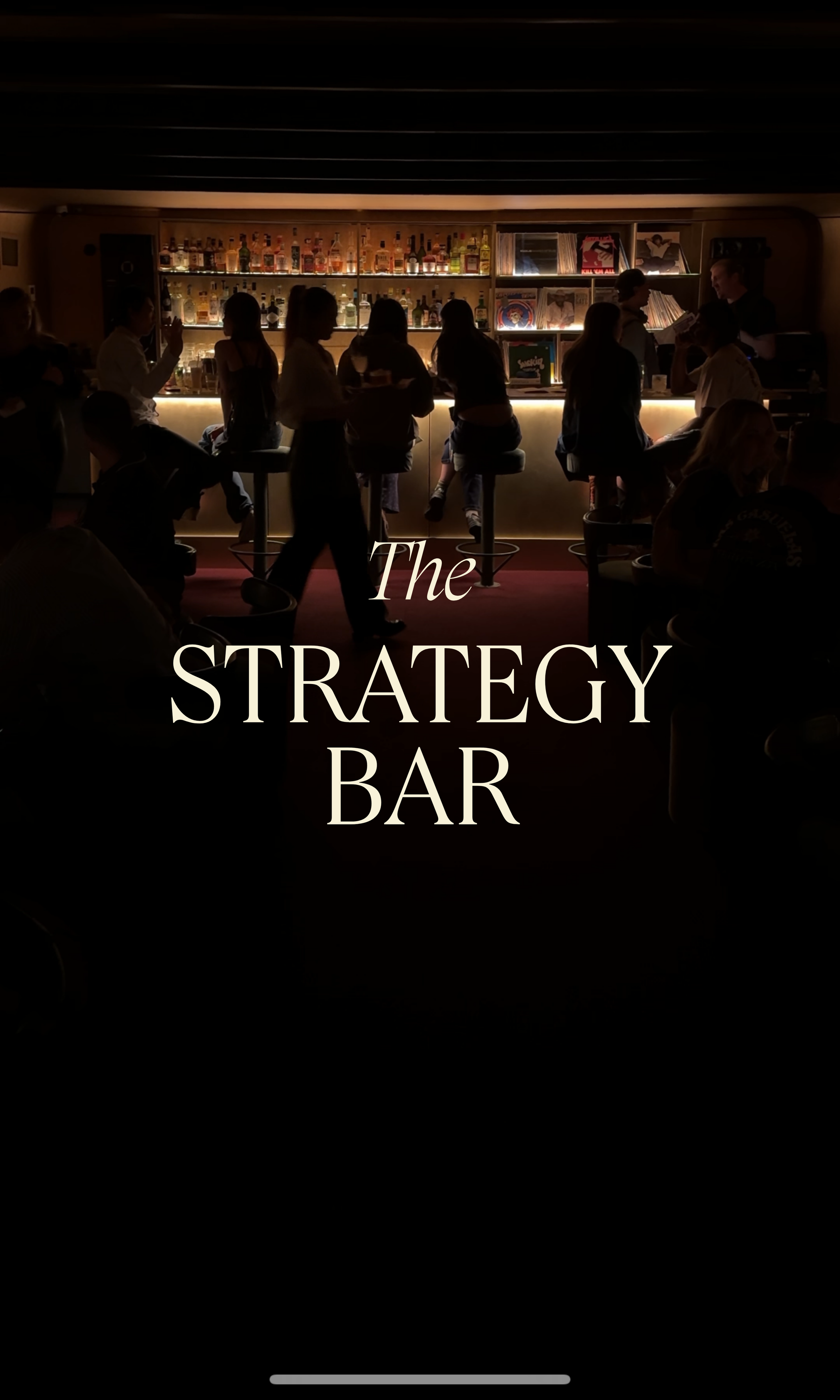 A dimly lit bar with people sitting and standing, behind a counter with various bottles of alcohol, and vinyl records displayed on the shelves. Text overlay says 'The Strategy Bar'.