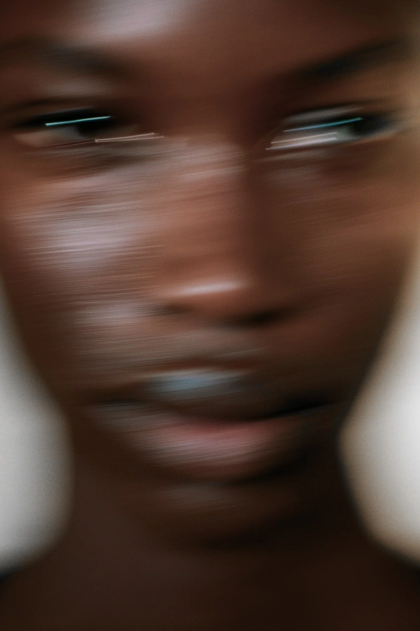 Close-up of a person's face with motion blur, focusing on the eyes and lips.