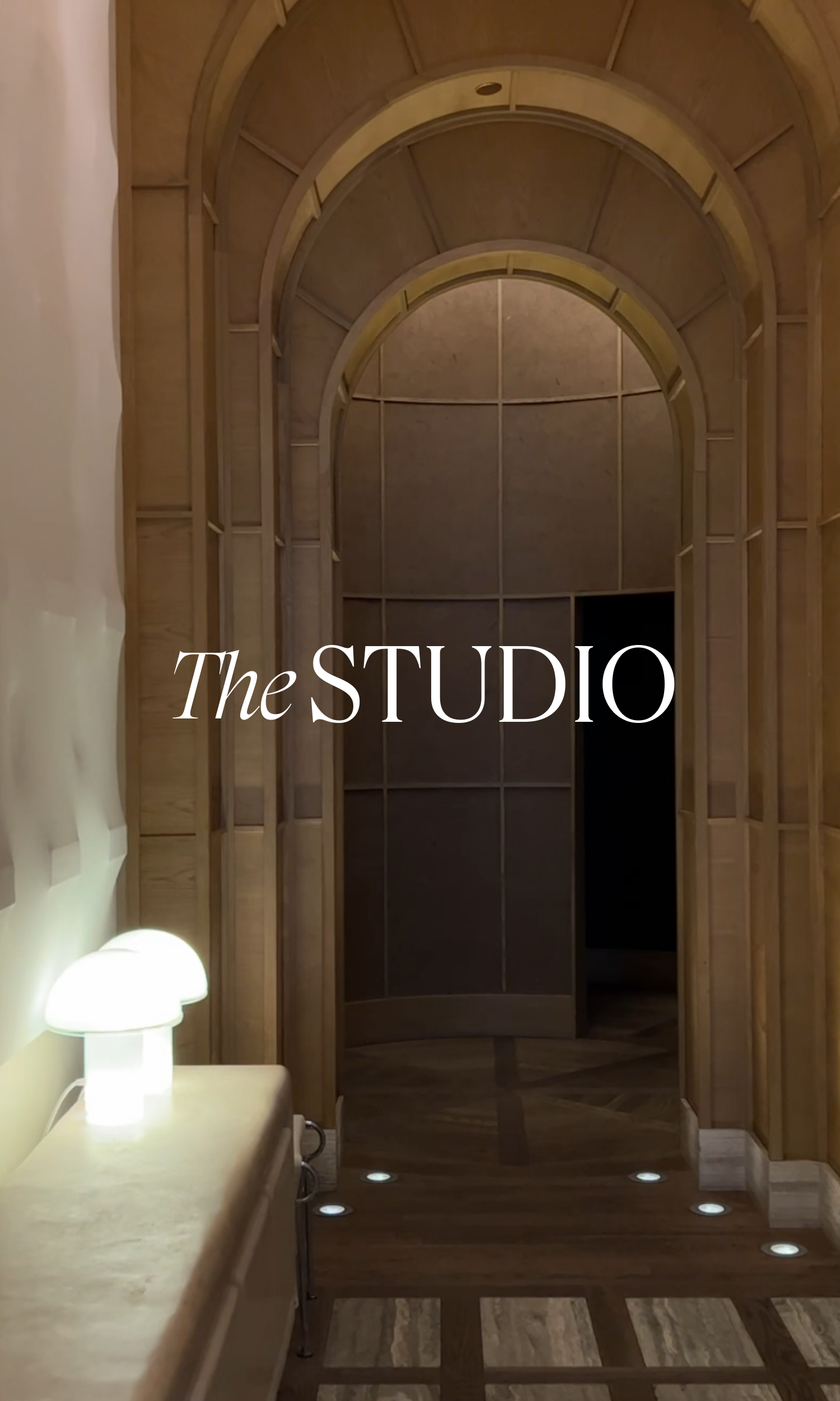 Interior shot of a wooden studio with a curved archway and wooden paneling, with the words 'The STUDIO' overlaid on the image.