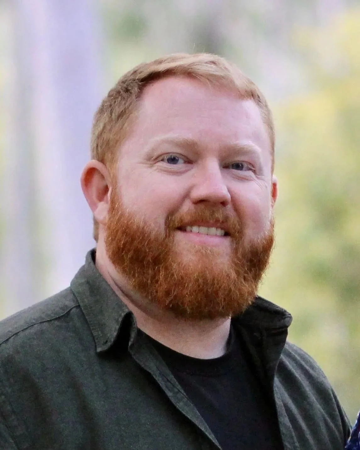 Ross' portrait smiling outdoors