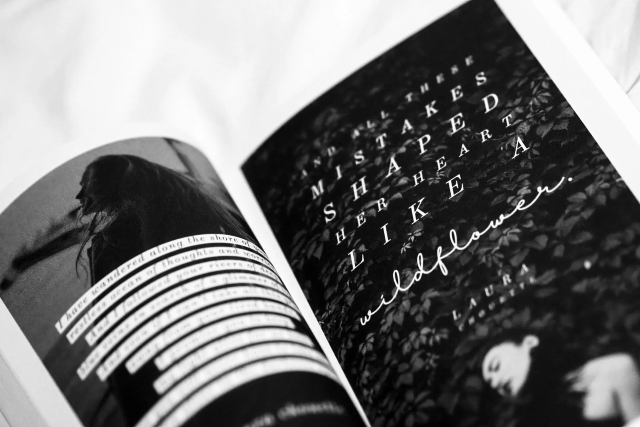 A black-and-white photo of an open magazine featuring a woman with long hair and text over the image, as well as a background of leaves.