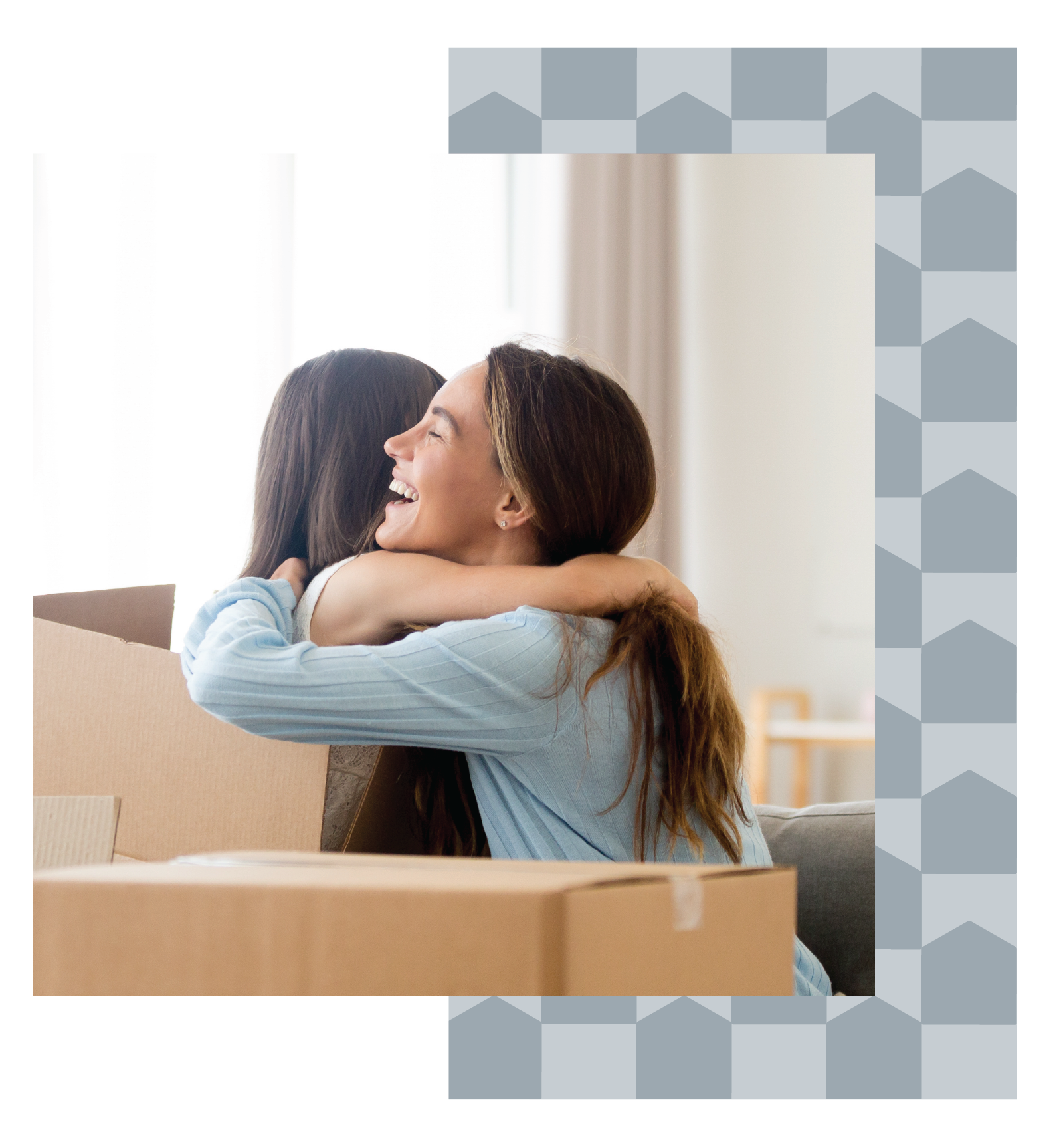Mother hugs her daughter who is sitting amongst moving boxes.