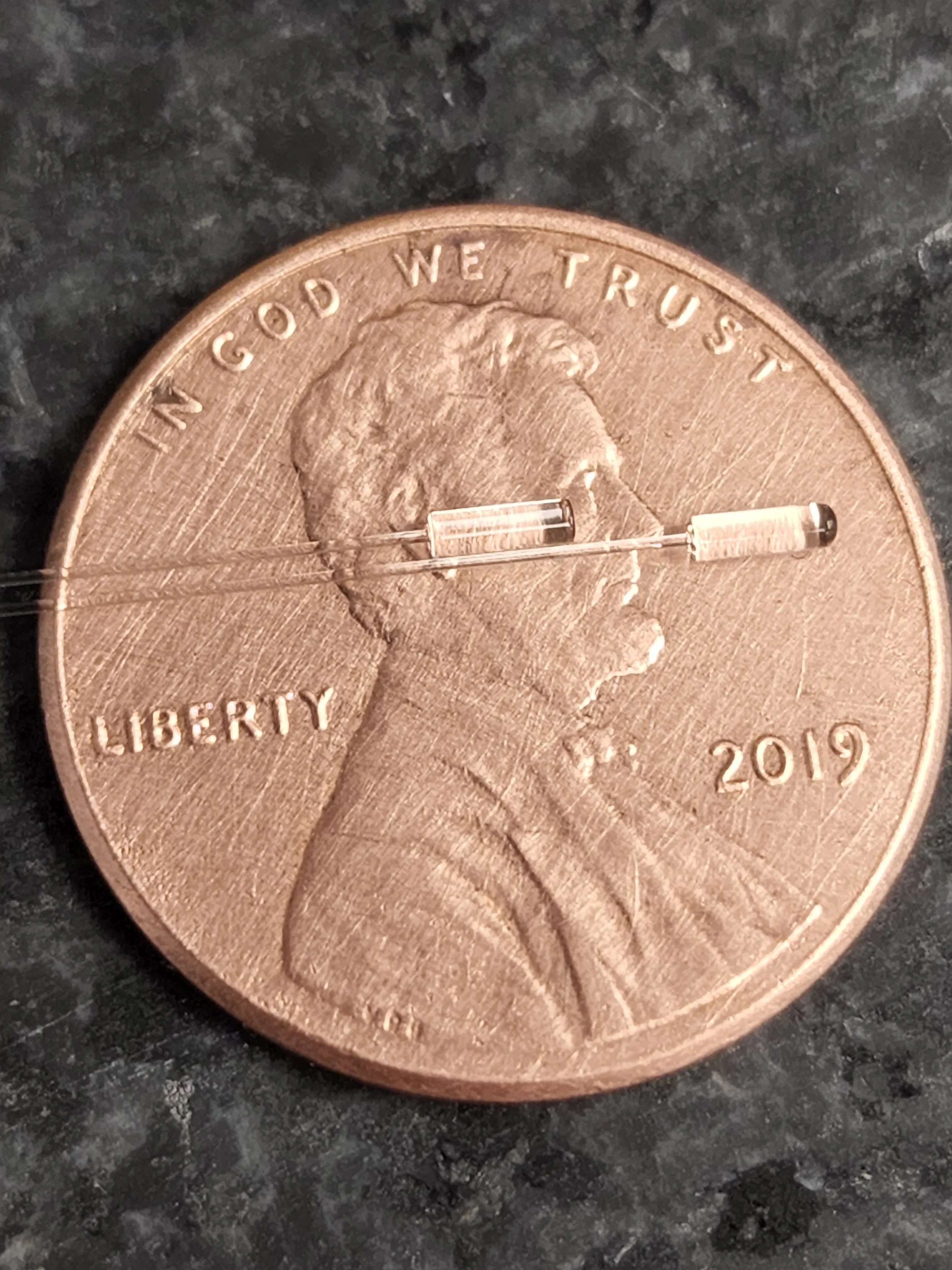 Lensed fiber endcaps on a penny for scale