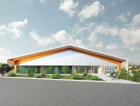 Exterior of God's Pantry Food Bank's proposed building with a modern design, featuring a white facade, orange trim, and a sloped roof. There are bushes and trees in front, and a person with a stroller near the entrance.