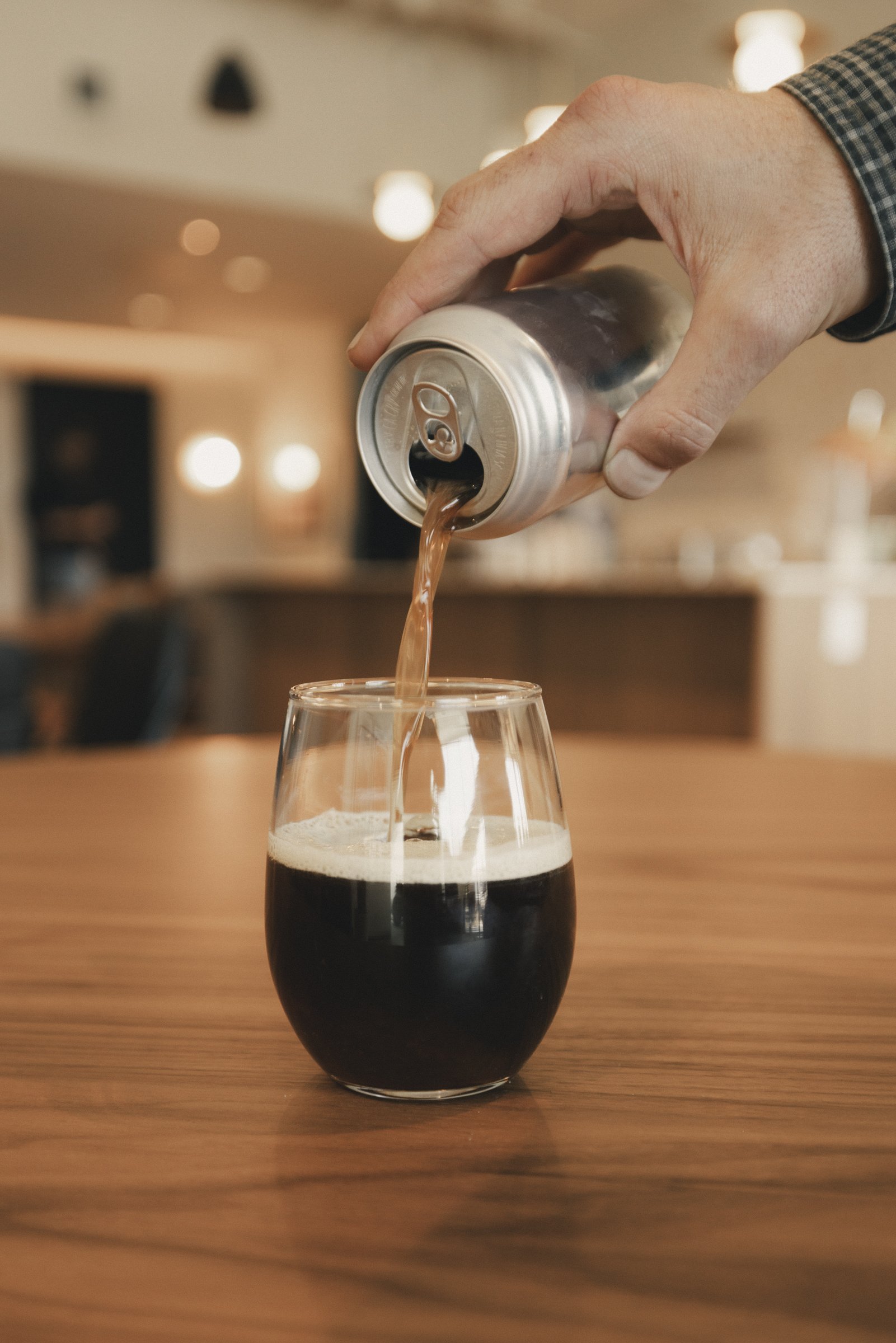Can of December Dark Roast Yaupon Nitro Cold Brew pouring into a glass