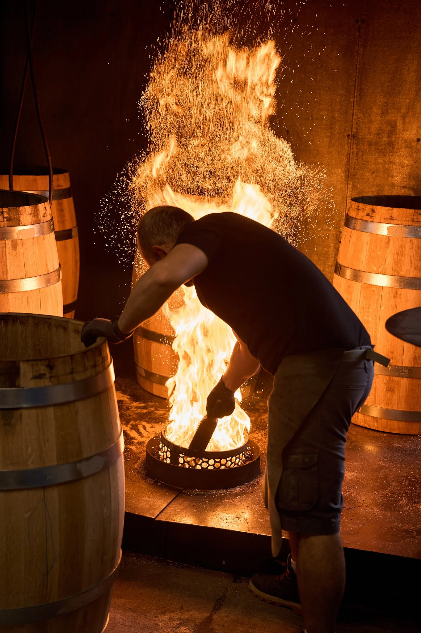 Un artisan tonnelier au travail maîtrisant le feu.
