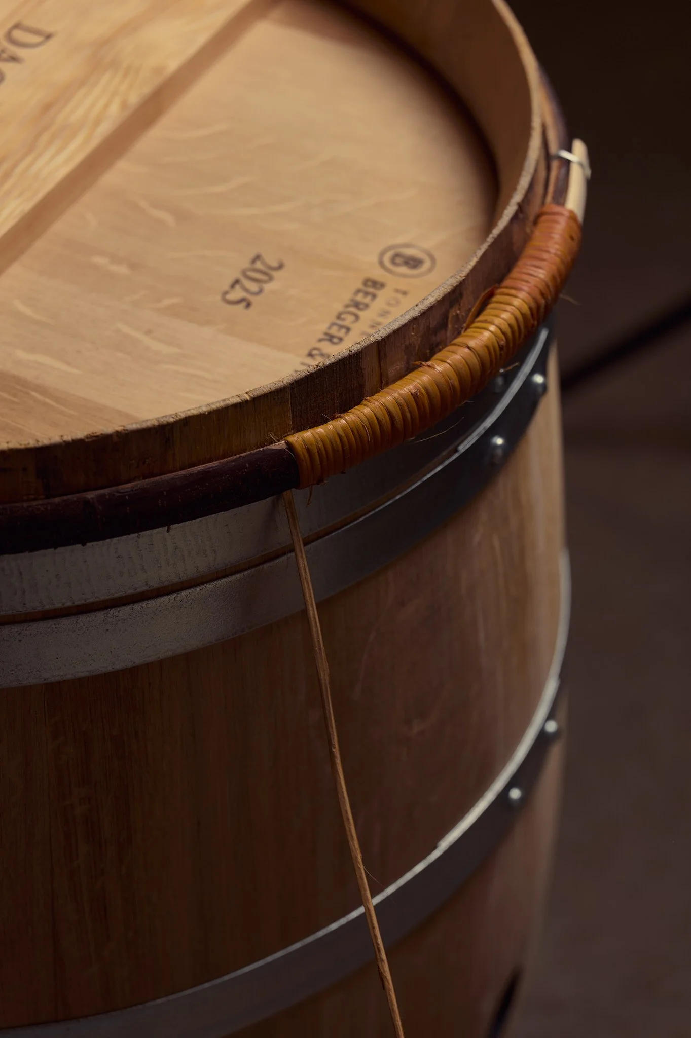 Un tonneau en bois avec un cerclage sur la partie haute.