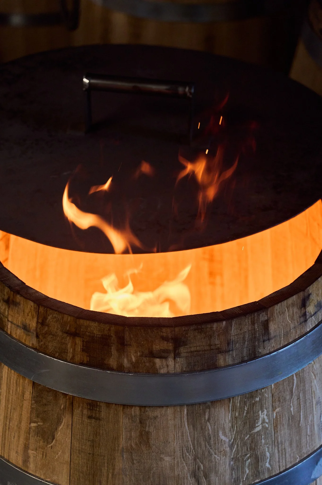 Zoom sur la chauffe de la barrique en bois dans la tonnellerie.