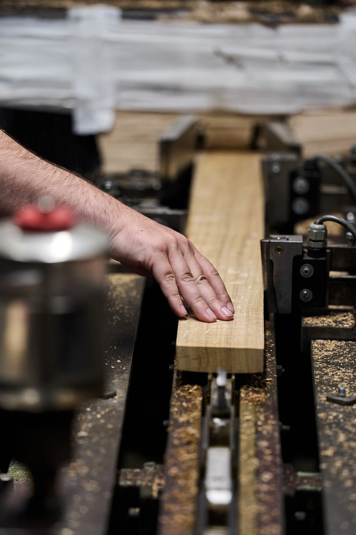 Mains d'un artisan travaillant une planche de bois sur une machine-outil
