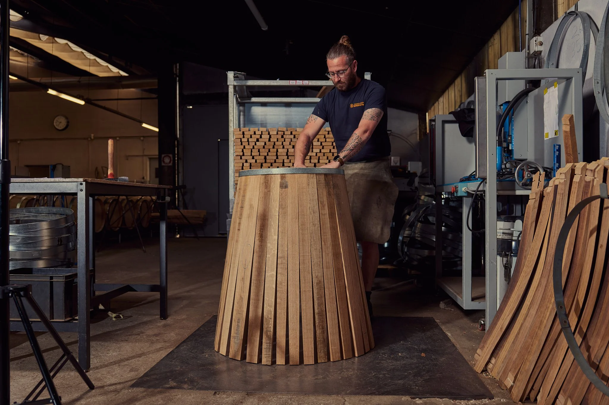 Un tonnelier en train de monter une barrique en bois.