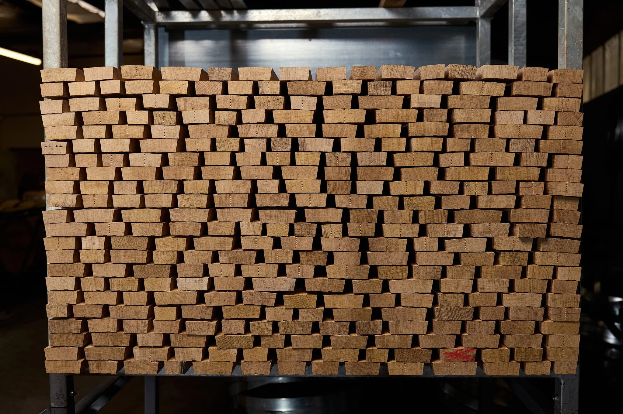 Une pile de douelles de bois empilées sur un support métallique dans l' atelier