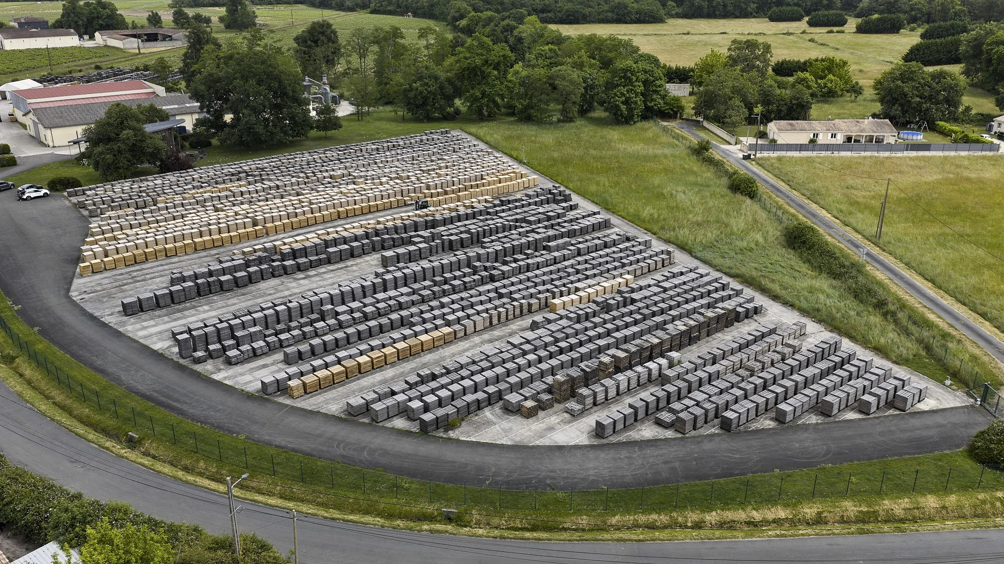 vue aérienne d'un entrepôt avec plusieurs rangées de blocs en béton, entouré de routes et de zones vertes
