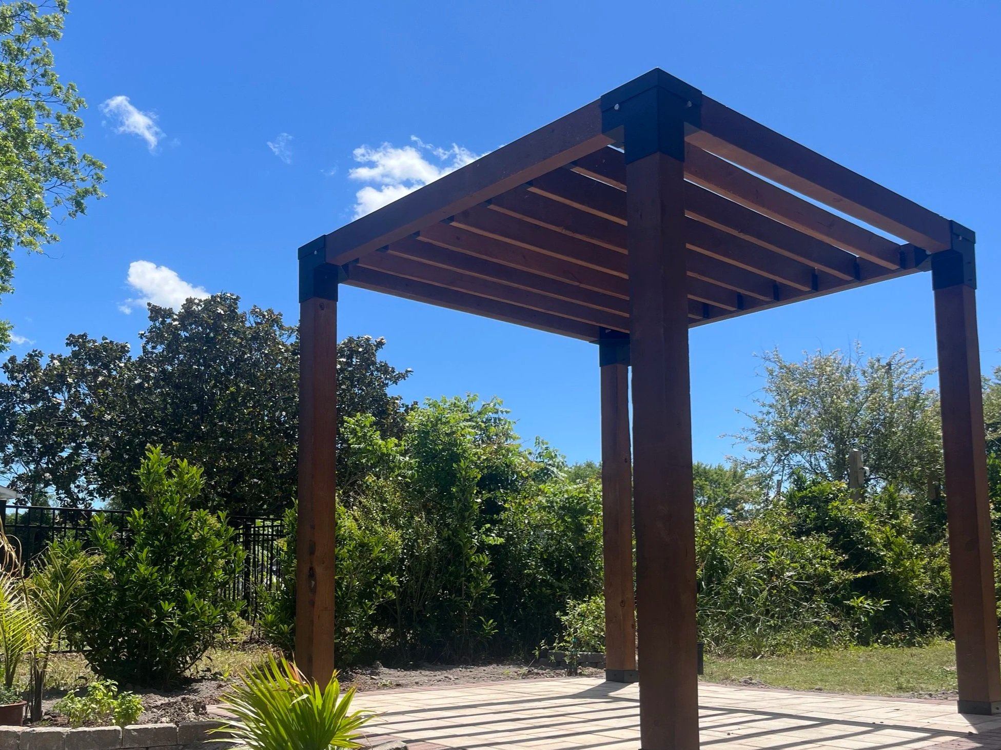 Contemporary pergola structure with a paver patio and landscape design