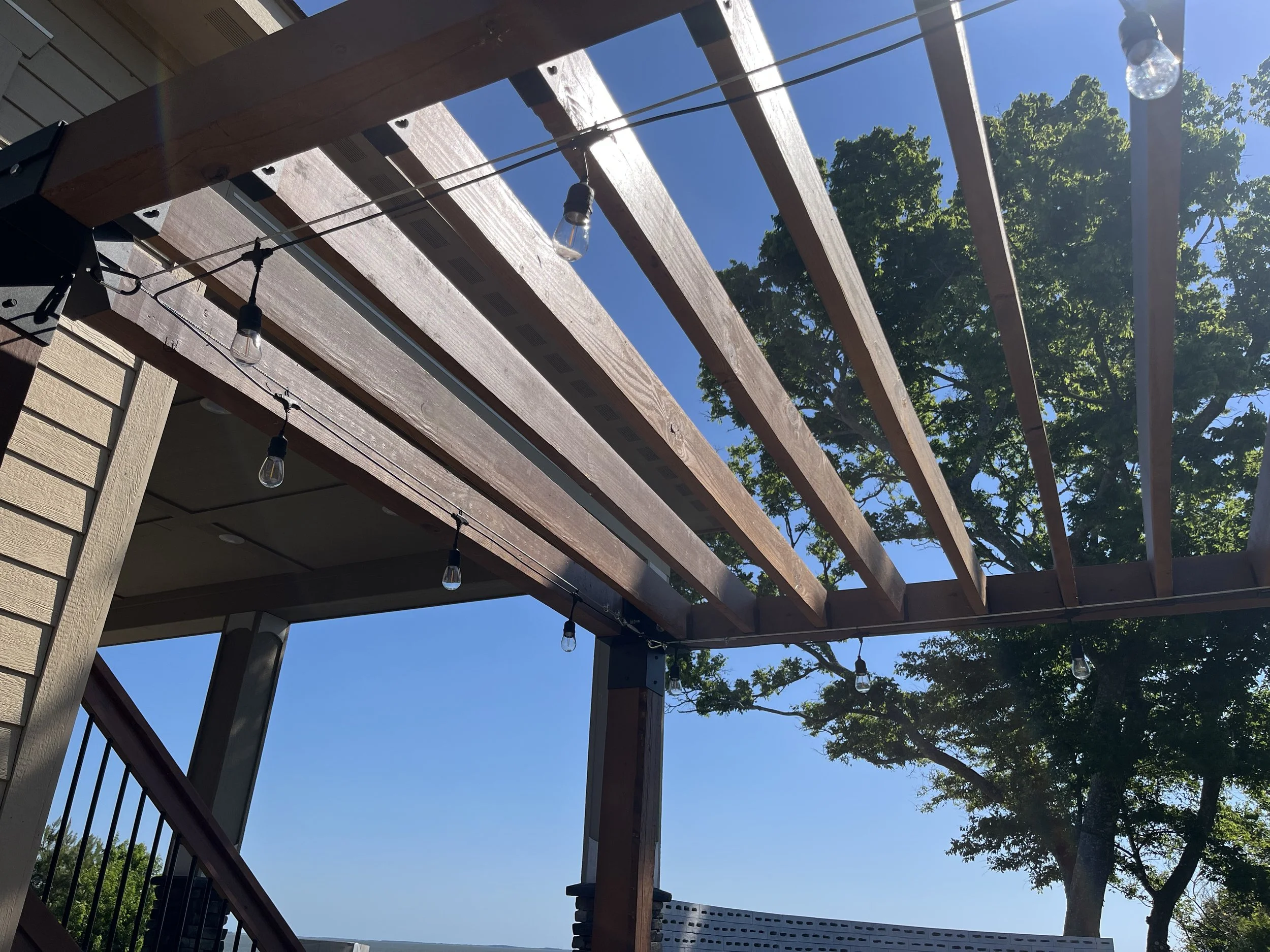 contemporary, solar powered string lights installed on a DIY wooden pergola kit by Lyoness Industries