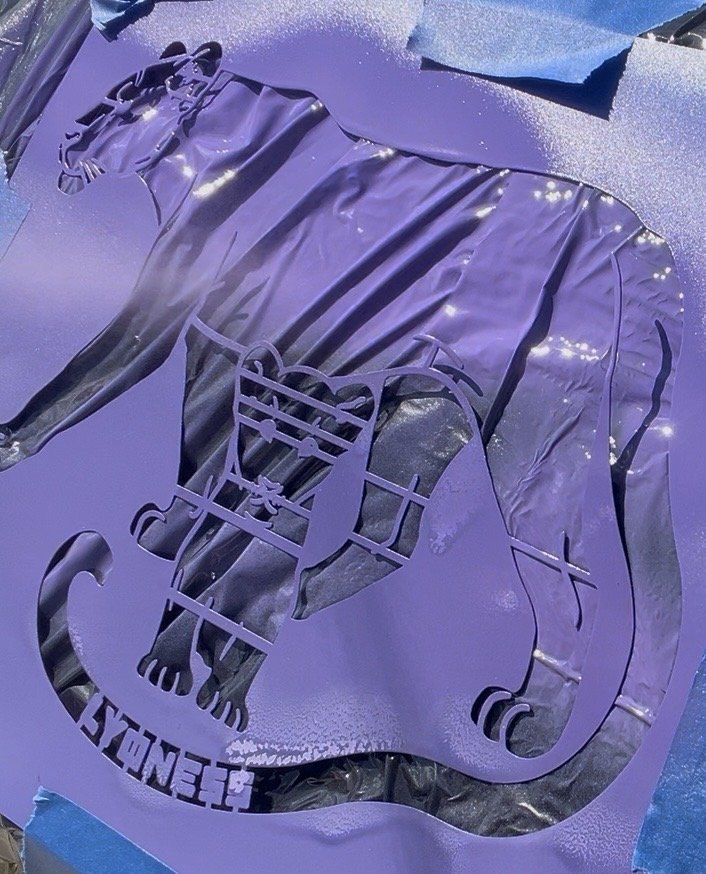 Lyoness Industries logo painted in purple onto a sturdy, modern pergola DIY kit