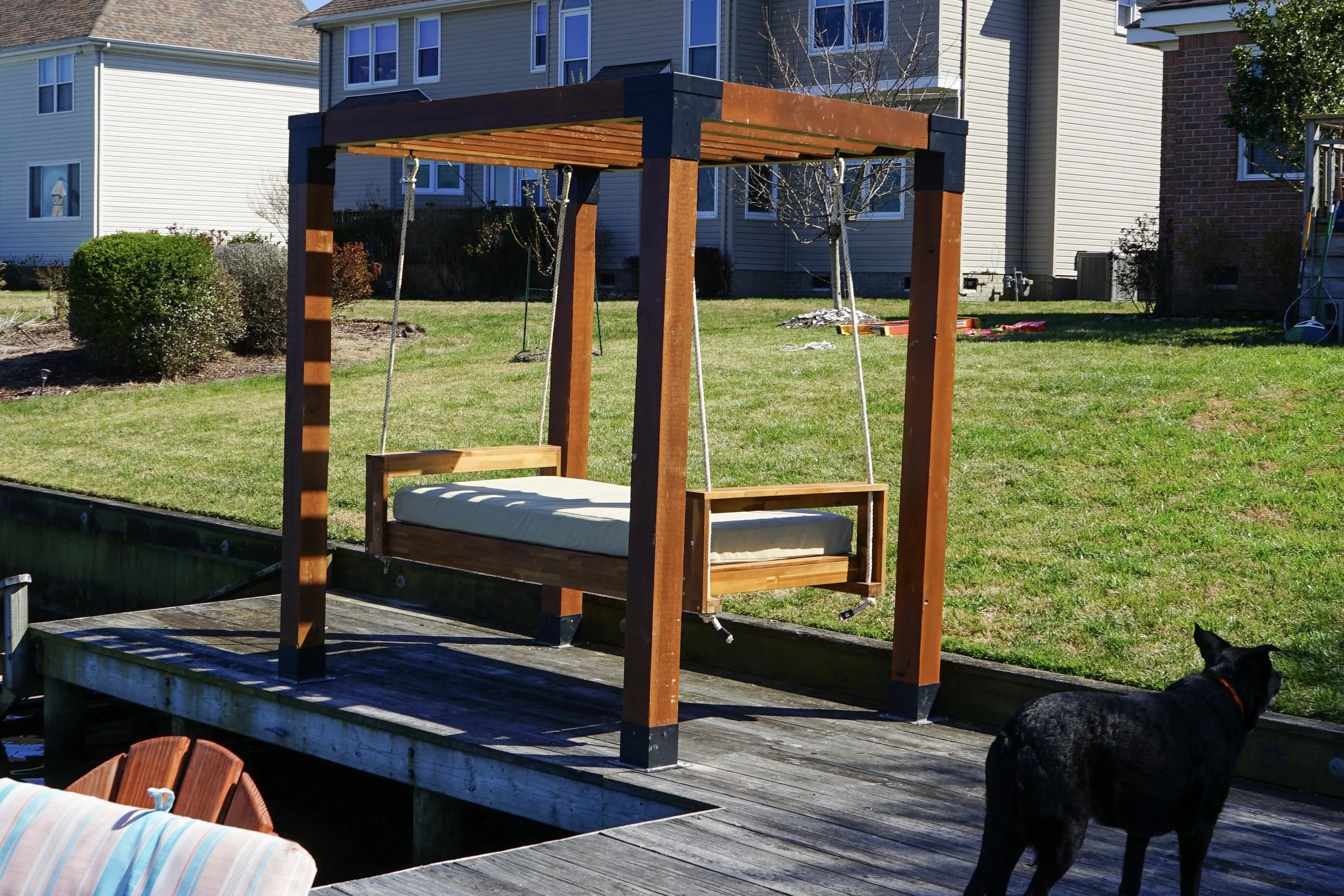 backyard suspended daybed on a boat dock with exterior mattress and pergola structure