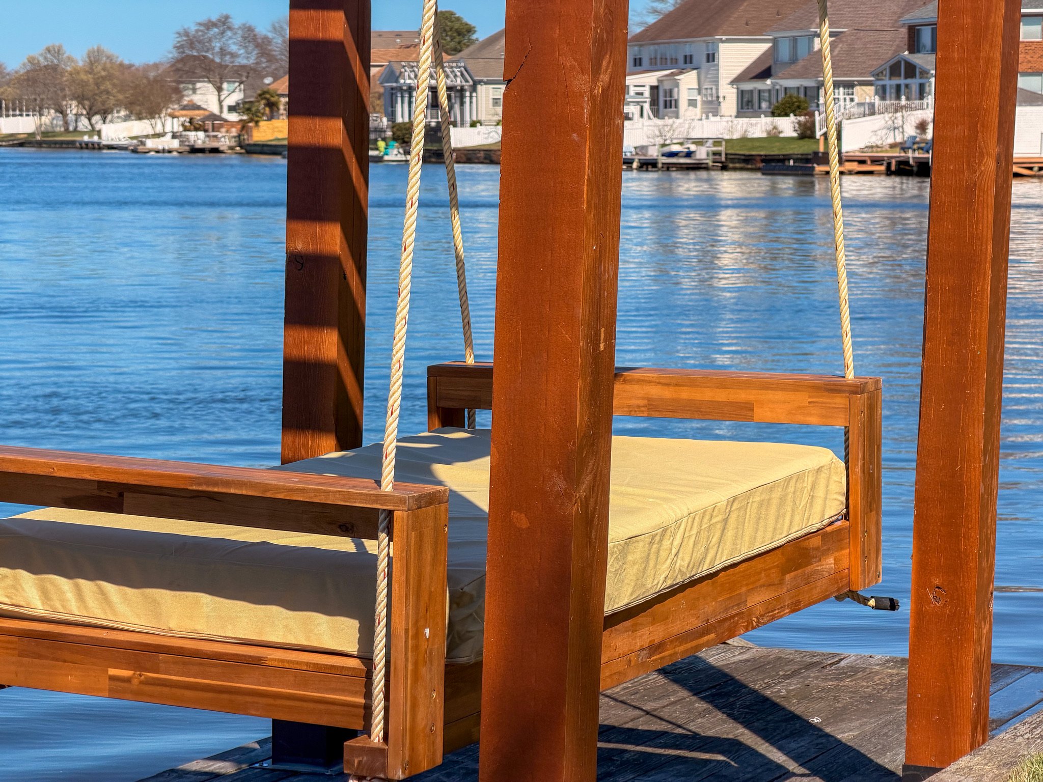 a building kit for a suspended daybed installed on a dock on a lake