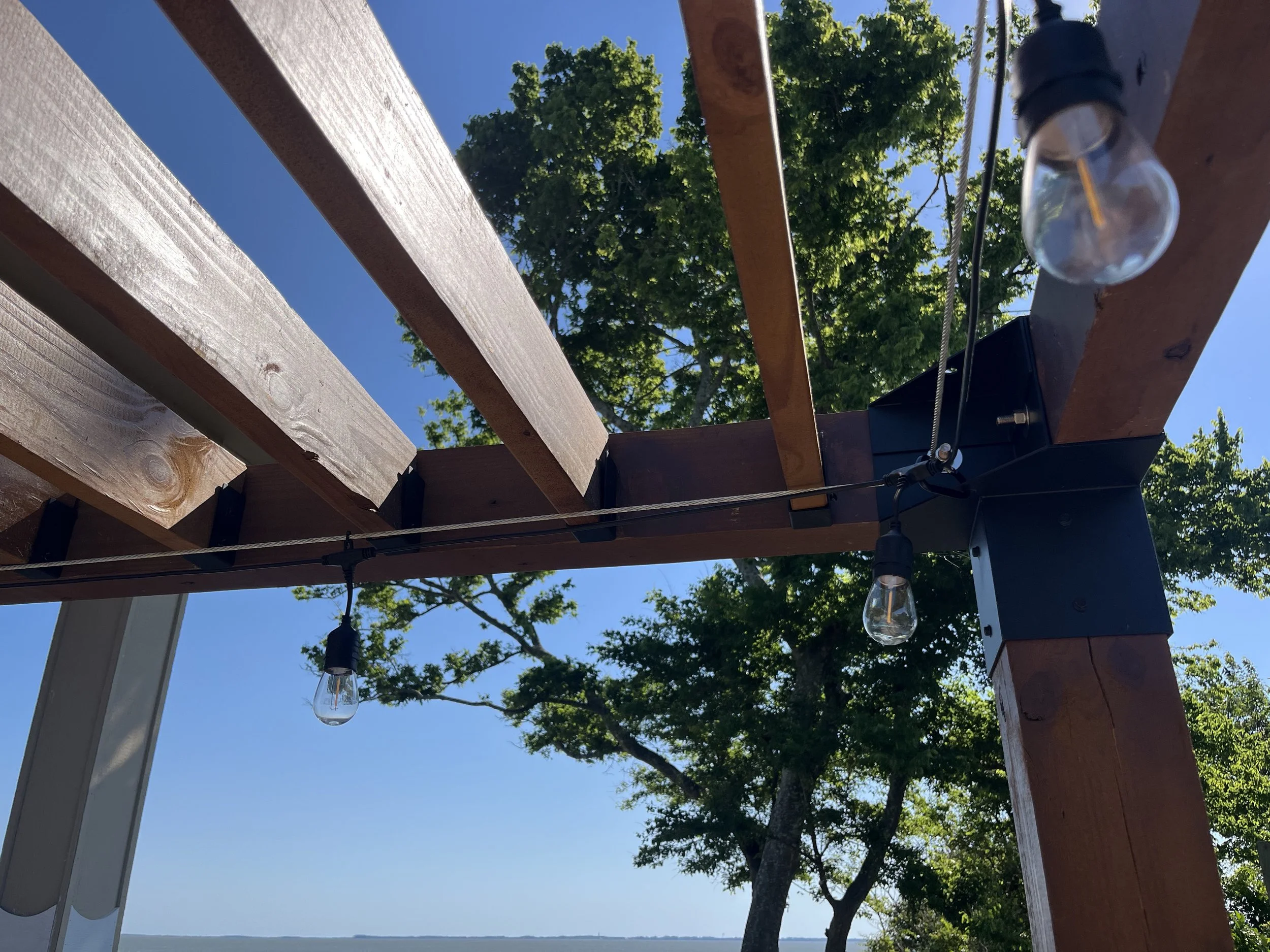 sunny day under a custom sized pergola with string lights in outer banks, North Carolina