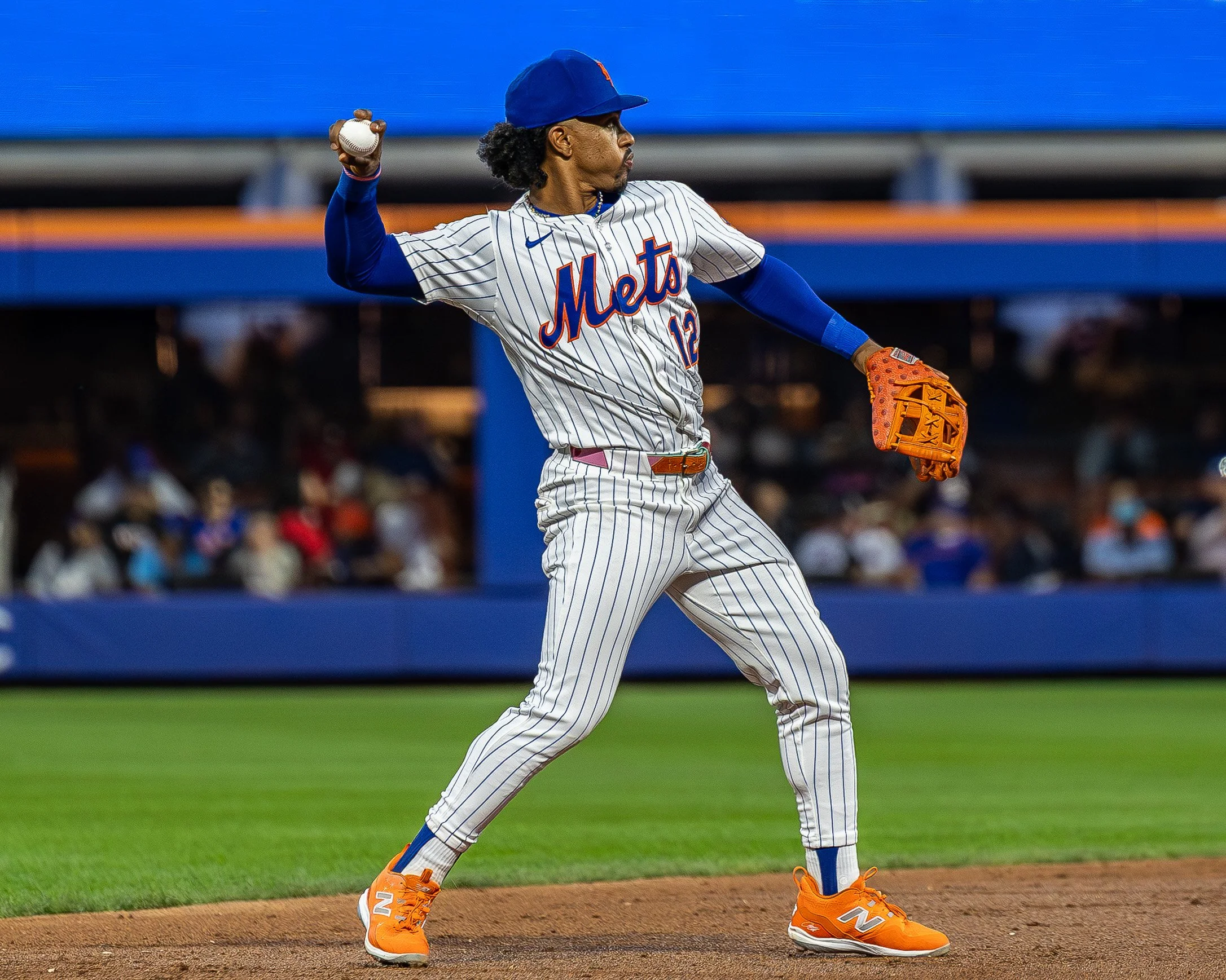 A baseball player from the New York Mets pitching on the field during a game.