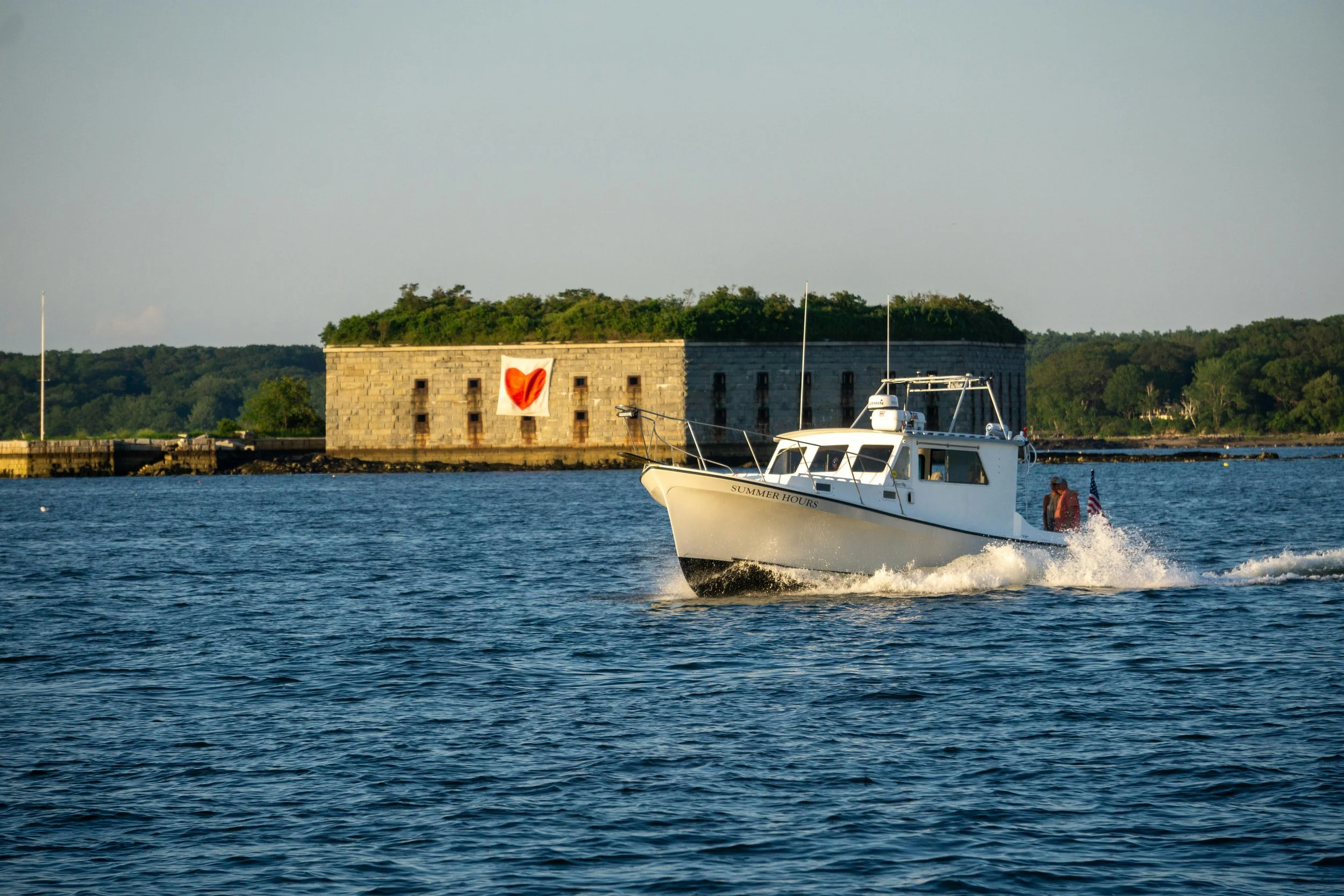 Portland Harbor with fishing boat passing Fort Gorges, Maine, symbolizing grounded men’s therapy near Portland.