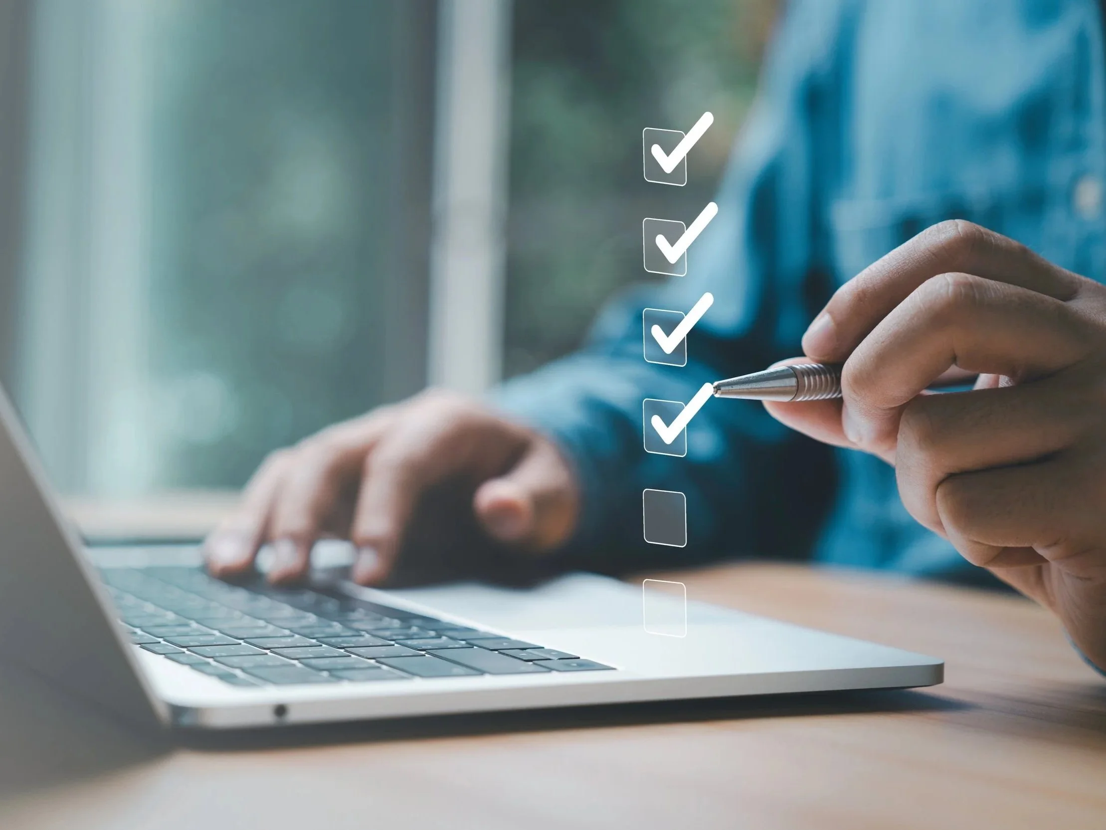 Person using a laptop with a digital checklist overlay showing checkmarks and an empty box.