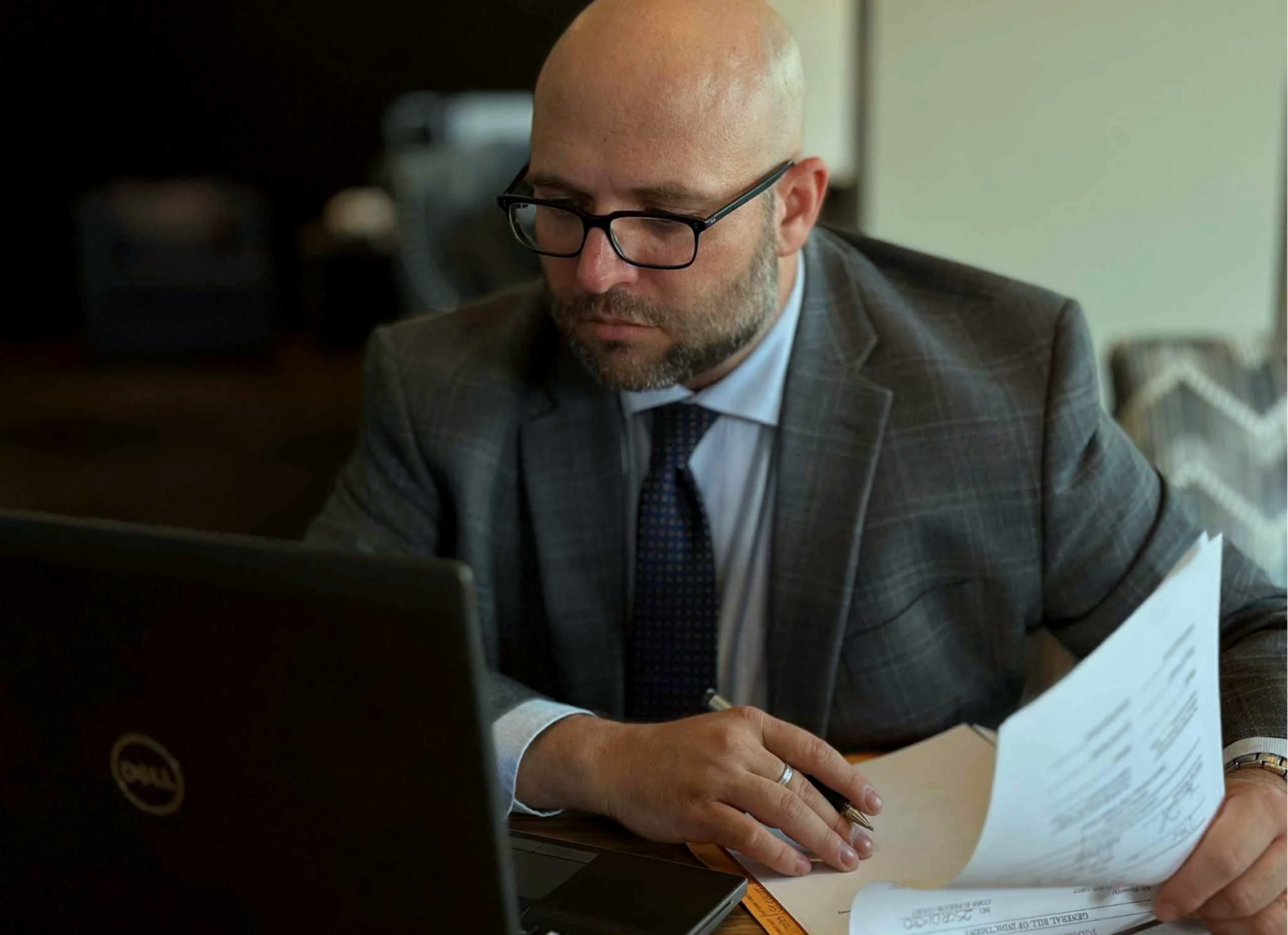 jeremy hager, lawyer, attorney, thoughtful man sitting at the desk, reading files