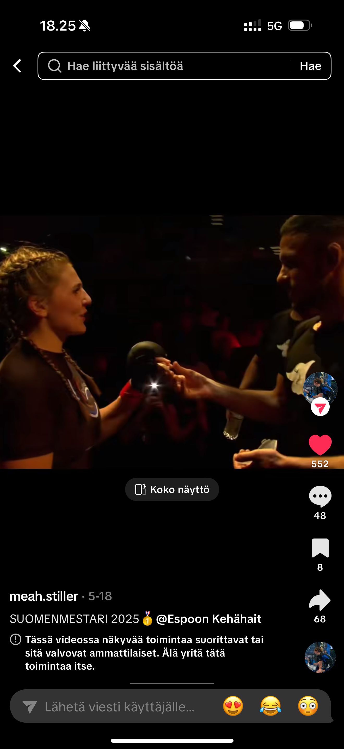 Nainen ja mies keskustelevat tuntemattomassa paikassa, ilmeisesti tapahtumassa, jossa joku urheilulaji tai kamppailulaji on läsnä. Kuva on otettu pimeässä ja henkilöitä on vain osittain valaistu.