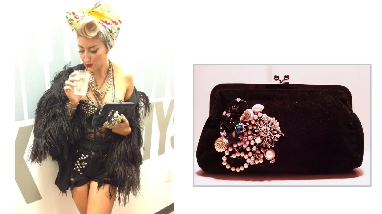 Neon Hitch earing a colorful headscarf, a black feathered jacket, and various jewelry, sipping a drink from a straw, and holding a clutch purse. To the right, a black velvet clutch purse adorned with jewelry, including rings and bracelets.