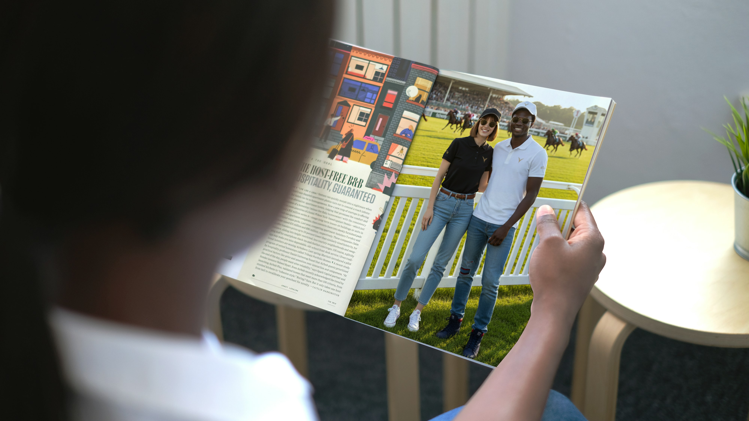 Une personne regarde un magazine avec une photo de deux personnes au zoo, avec chevales dans un paddock en arrière-plan