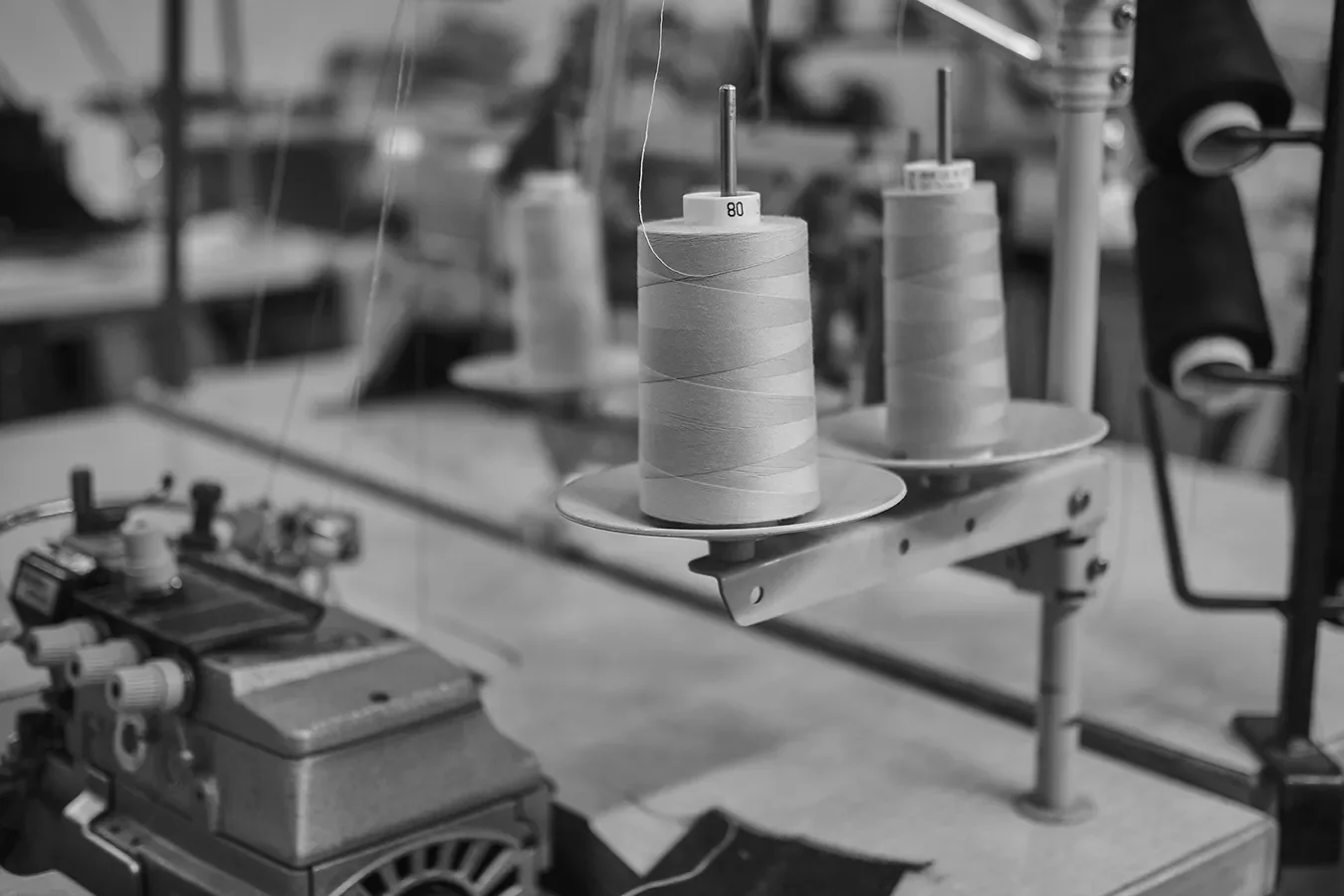 Spools of thread on a sewing machine in a textile manufacturing setting.