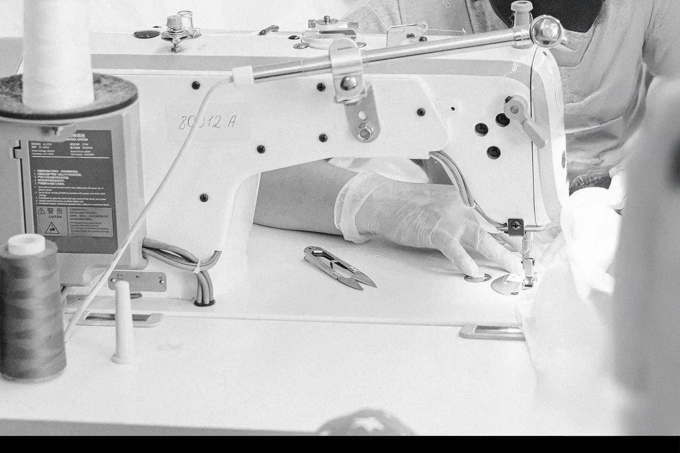 Medical professional using a sewing machine for suturing or stitching in a clinical setting.