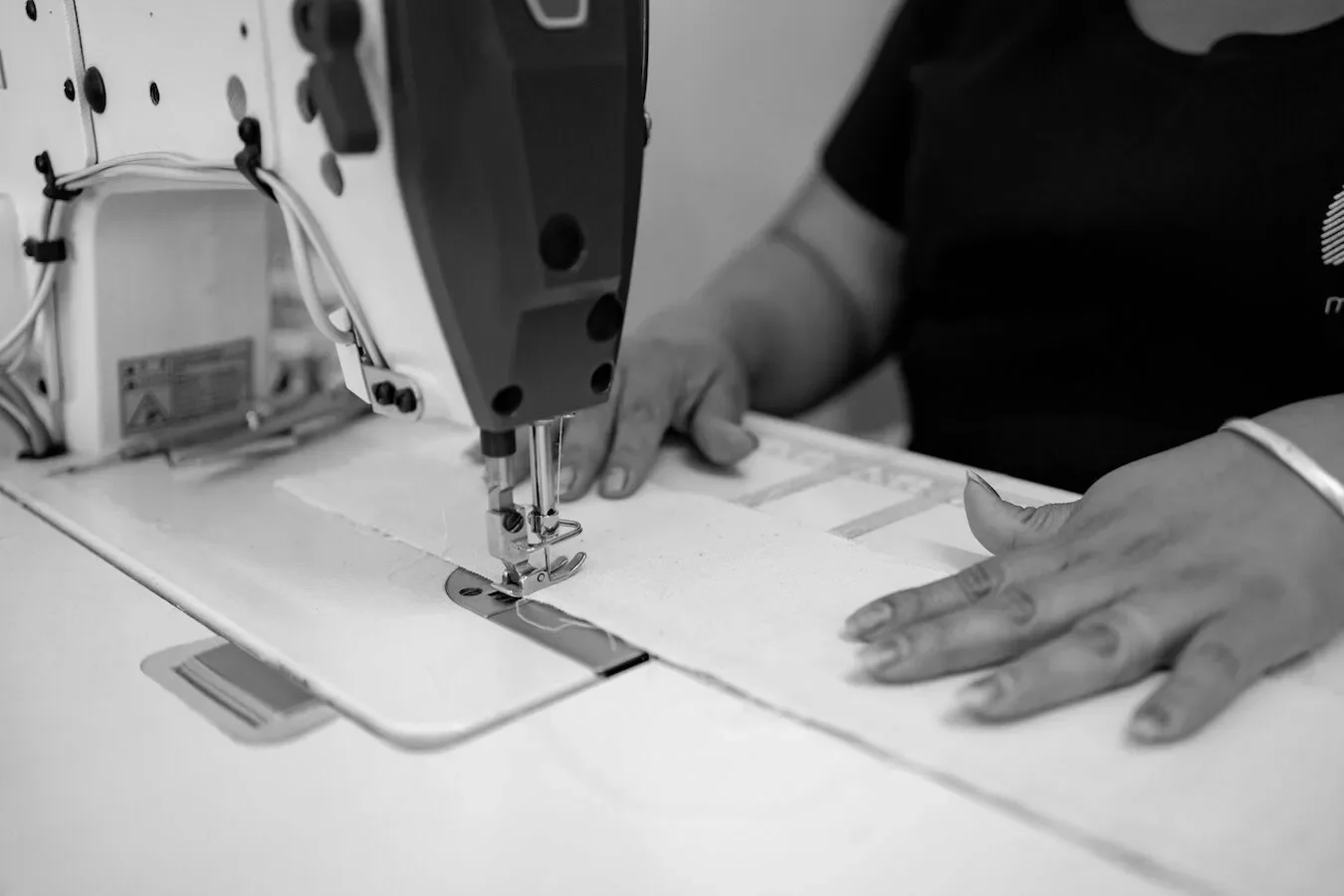 A person sewing fabric with a sewing machine.