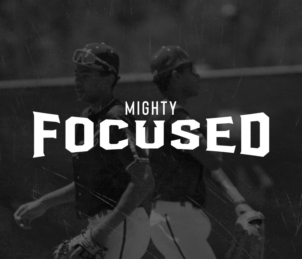 Two baseball players back-to-back, wearing helmets and uniforms, with the text 'Mighty Focused' overlaid.