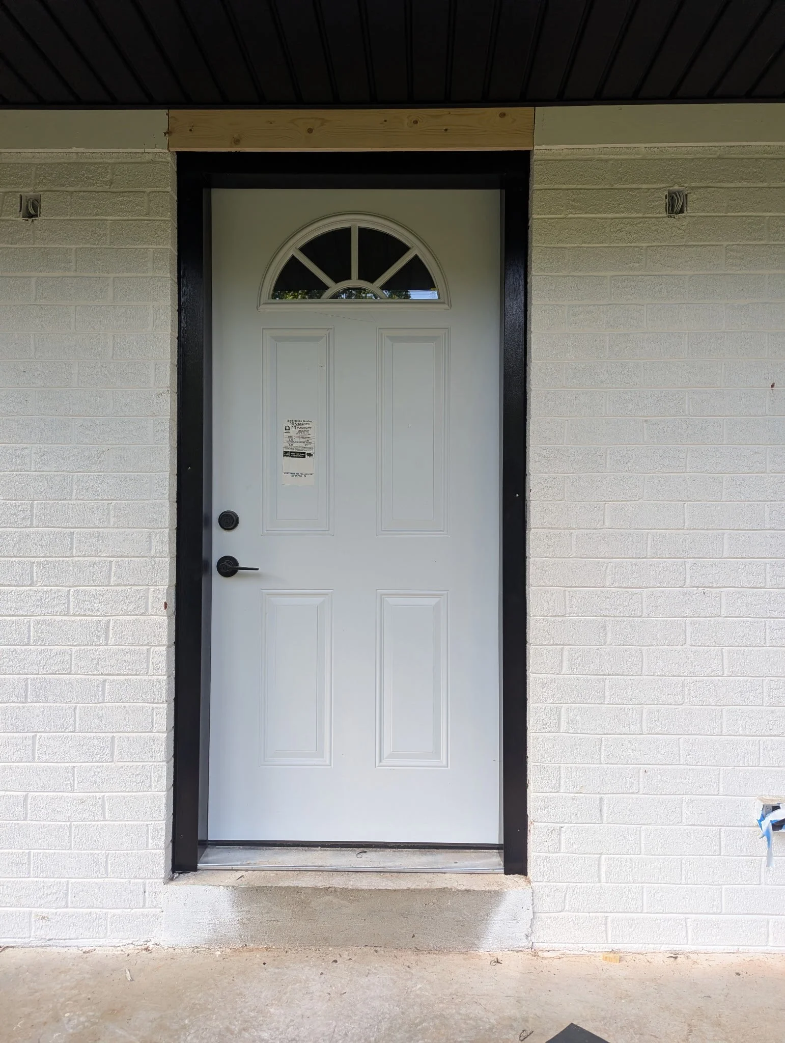 New front entry door installation with black exterior trim completed by Lil Fellers LLC on a brick home in Clarksville, TN.