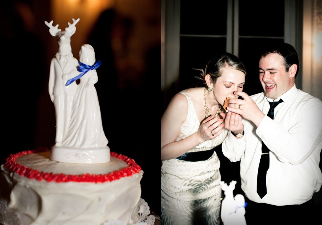 A wedding cake with a white figurine topper resembling a couple with a reindeer and antlers, and a woman and man in wedding attire sharing a piece of cake during their wedding celebration.