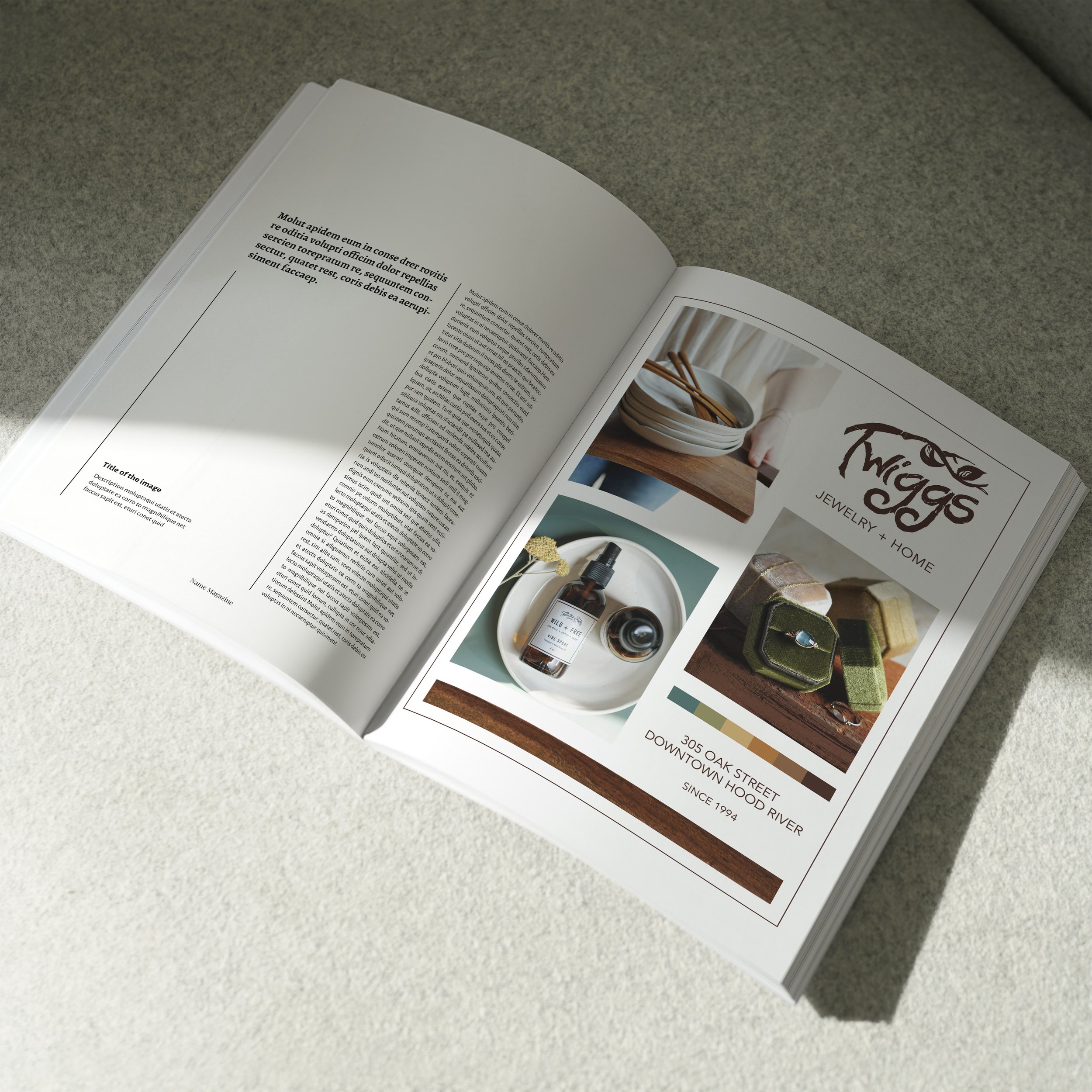 Open magazine on a table showing an advertisement for jewelry and home decor items, including a sign that reads 'Twiggs Jewelry + Home', along with images of bowls, bottles, and bags, with sunlight casting shadows.