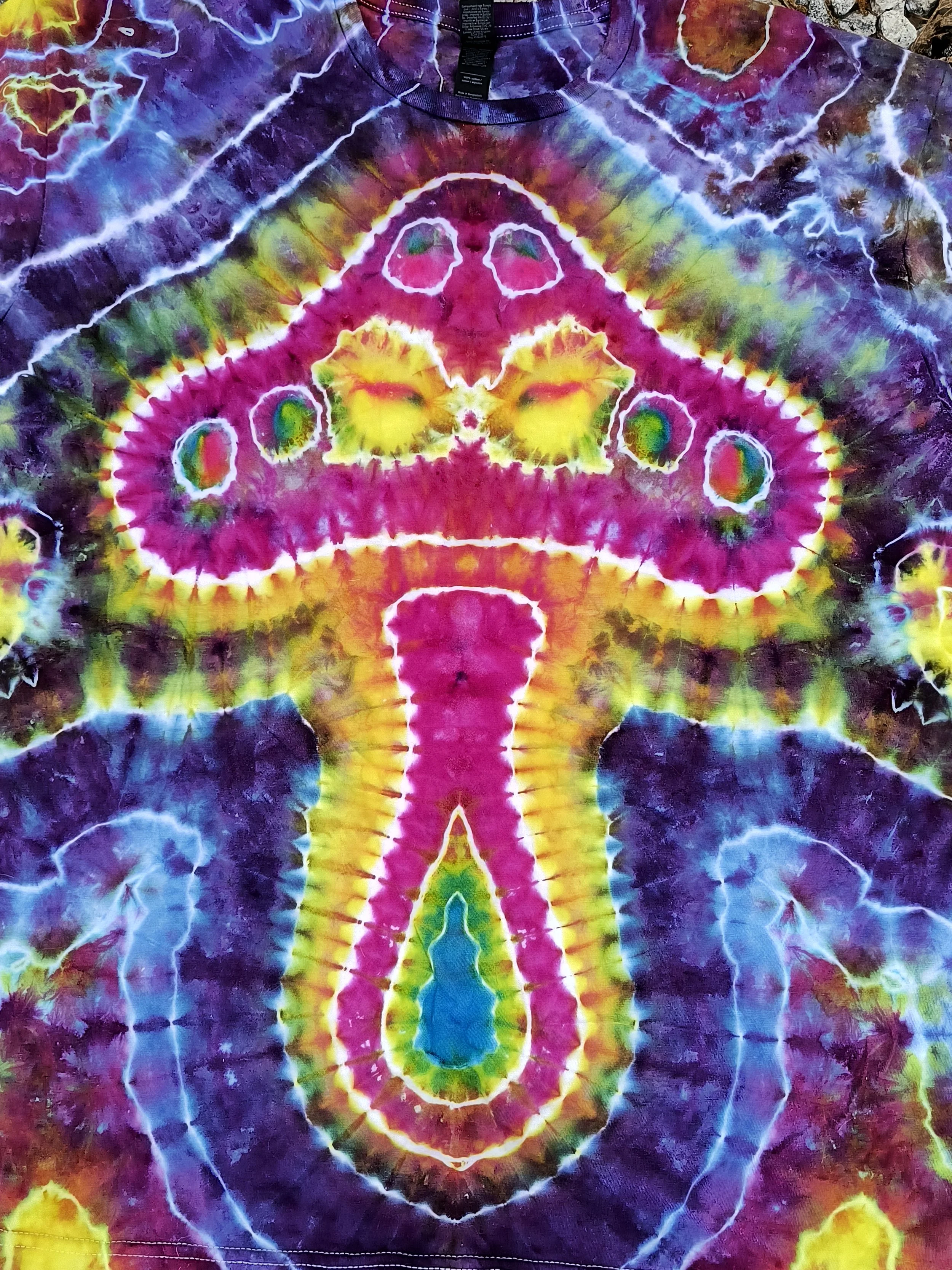 Colorful tie-dye shirt featuring a mushroom pattern with vibrant colors including purple, yellow, green, blue, and pink.