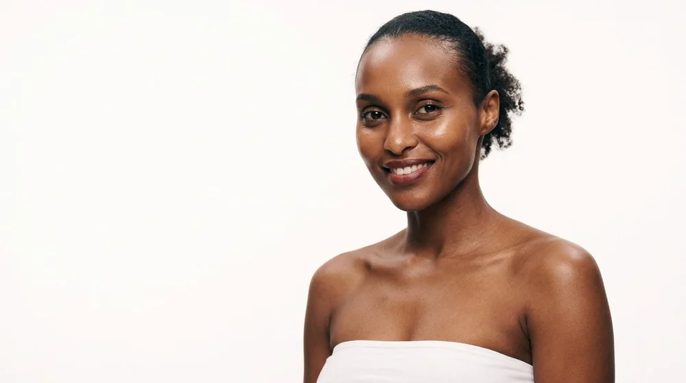 Épilation laser sur peau noire à Évian : femme souriante, épaules nues, guide du Dr Samson