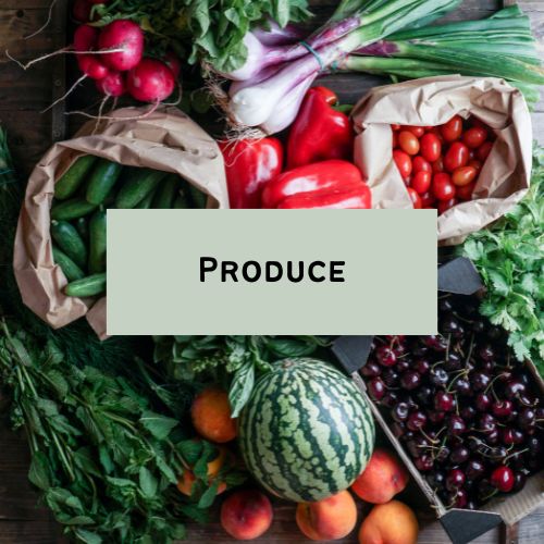 Fresh vegetables including radishes, cucumbers, onions, tomatoes, watermelon, cherries, and peaches arranged on a table with a sign that says 'Produce'.