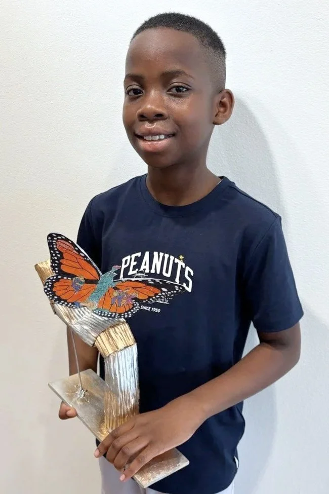 Nathan Adeosun, young Elgin artist selected for the America 250 Public Art Project, holding a butterfly sculpture symbolizing hope, transformation, and unity.