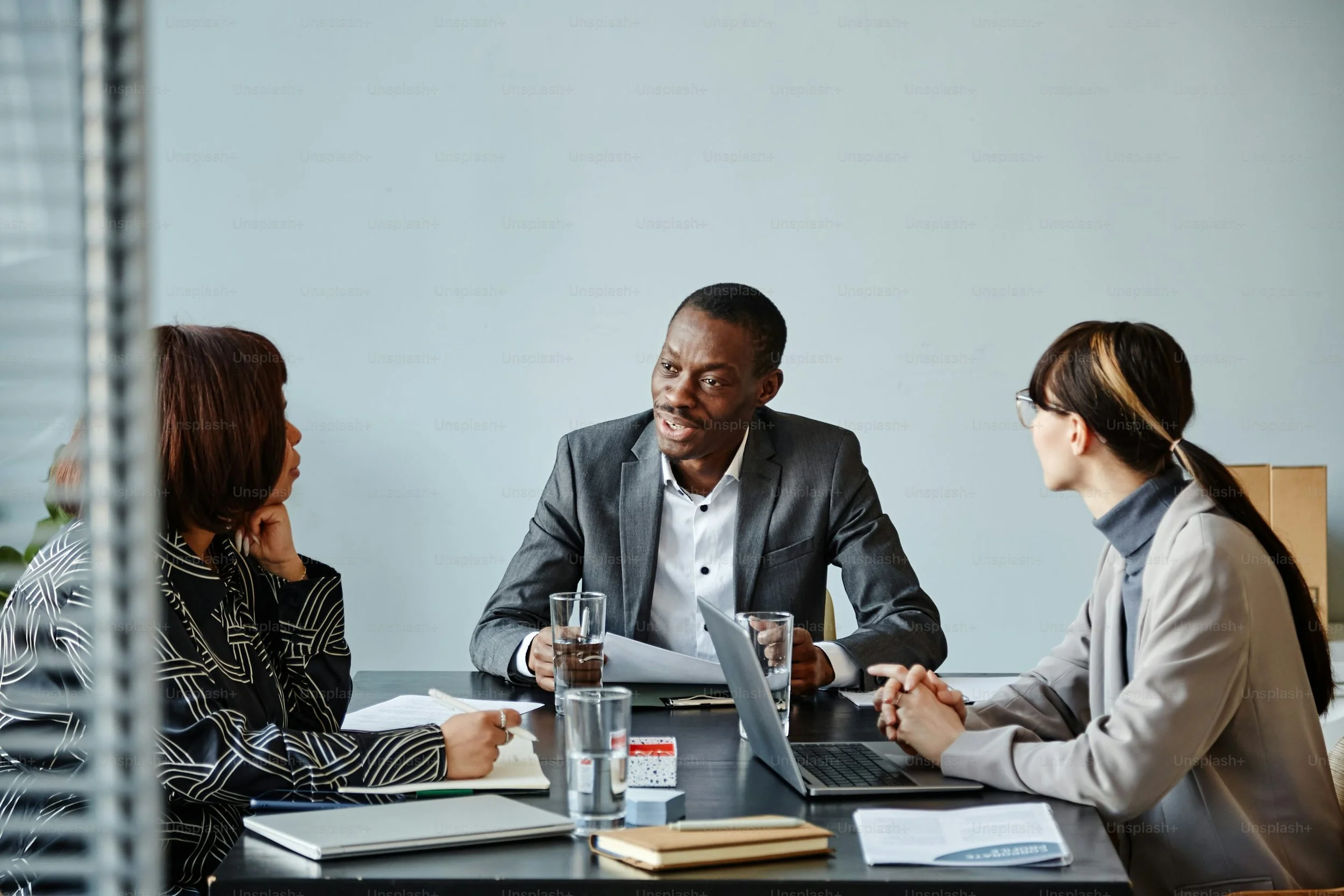 Three professionals having a business meeting in an office conference room.